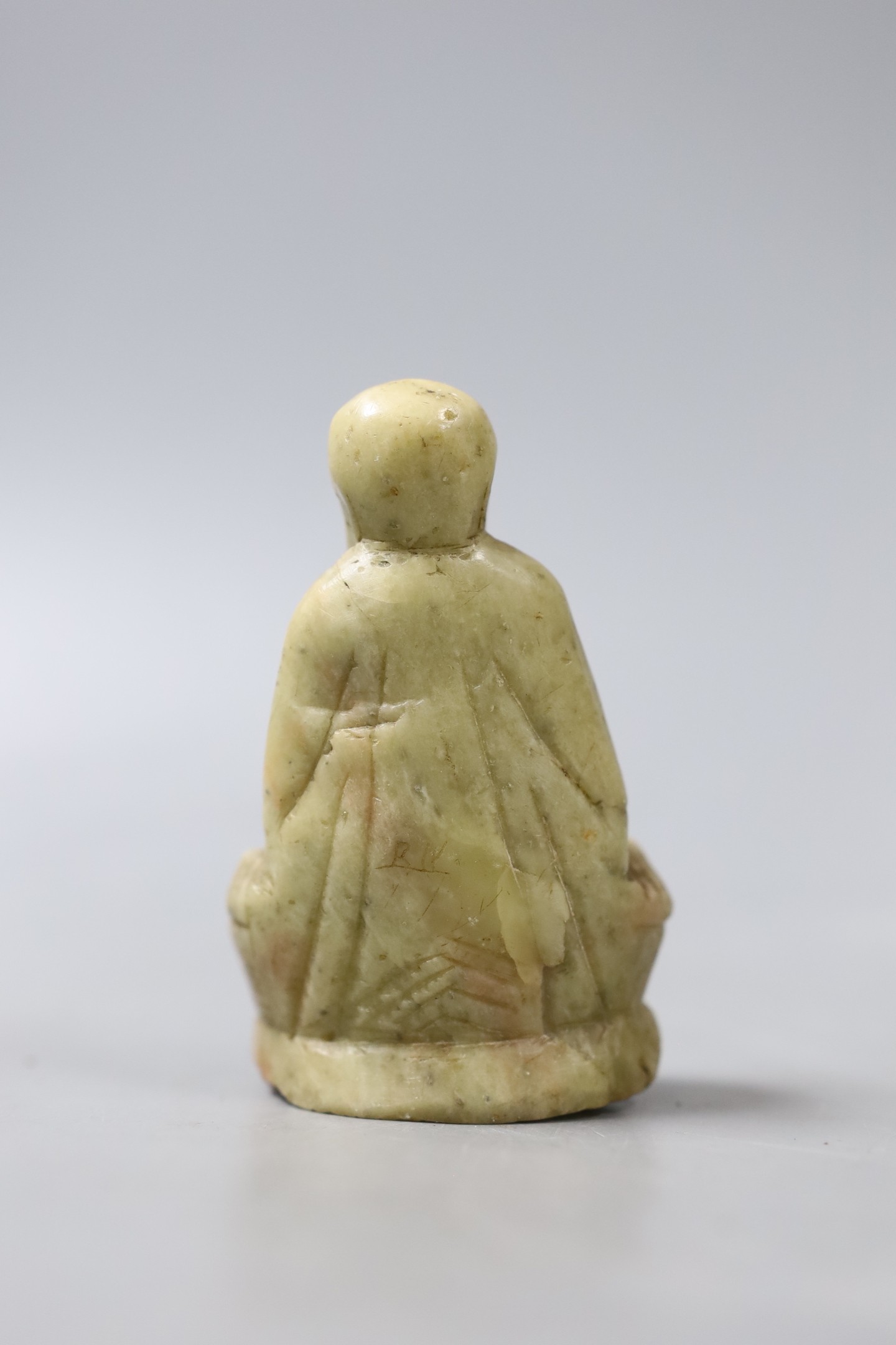 A carved soapstone figure of a seated smiling Buddha - 8cm tall